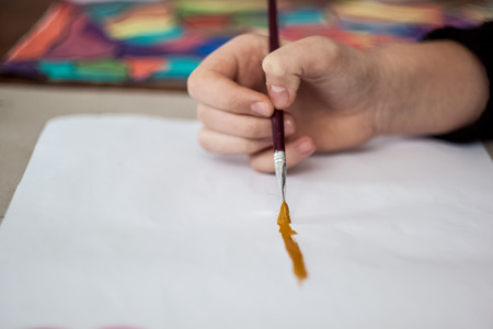 Girl painting with brush and colorful paintの写真素材