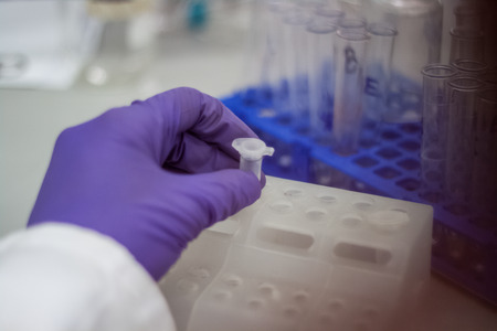Modern scientist working in biotechnological laboratory equipment for research with pipettes and...