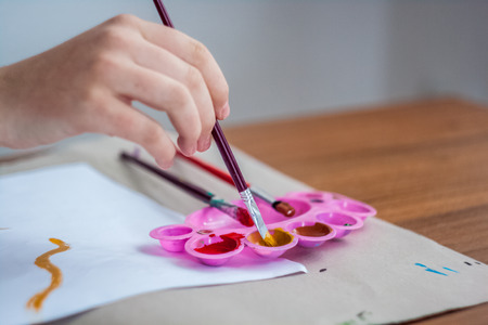 Girl painting with brush and colorful paintの写真素材