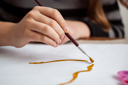 Girl painting with brush and colorful paintの写真素材