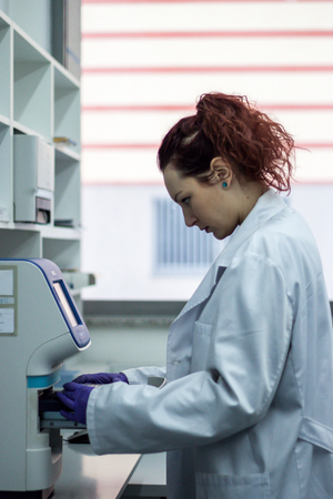 Scientist or researcher or PHD student take DNA samples from flask for analysis in a biotechnology laboratoryの写真素材