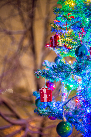 Christmas decorations on a branch of fir, night idyll, with snow and lamps in various colorsの写真素材