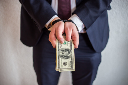 Bribe and corruption, offered cash to a man in a suit, he takes money and participates in bribery and corruptionの写真素材