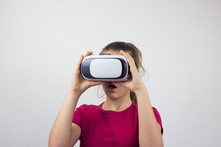 Teenager with virtual reality glasses on the head, enjoying watching, amazing technology, white background, studioの写真素材