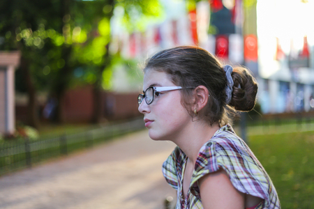 Girl on the street, thoughtful facial expressions, eve, sunset, parkの写真素材