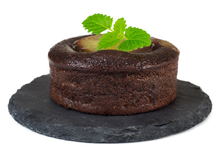 Chocolate cake served on modern slate plate with mint leaf isolated on white backgroundの写真素材