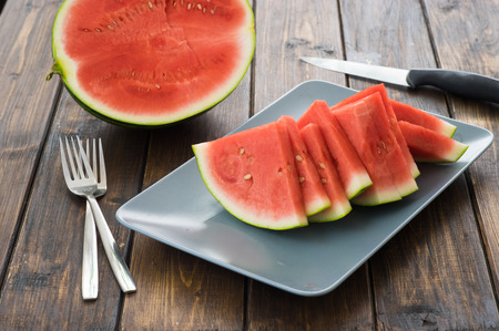 Slices of watermelon on wooden table in rustic styleの写真素材