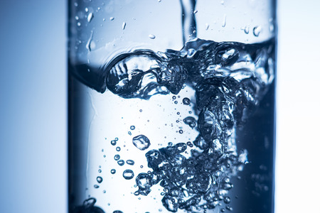 Close up of crystal water splash in a glassの写真素材