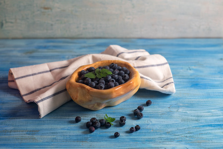 Wooden bowl full with blueberry on vintage blue wooden tableの写真素材