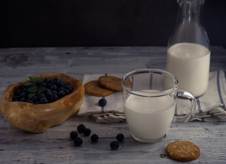 Still life with cookies, milk and blueberry on dark background in rustic styleの写真素材