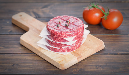 Raw patty and tomatoesの写真素材