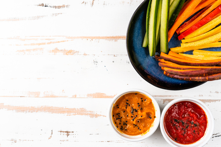 Colorful vegetable sticks in a blue plate on white background. Copy spaceの写真素材