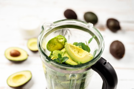 Top view of blender with avocado peaces on white backgorundの写真素材