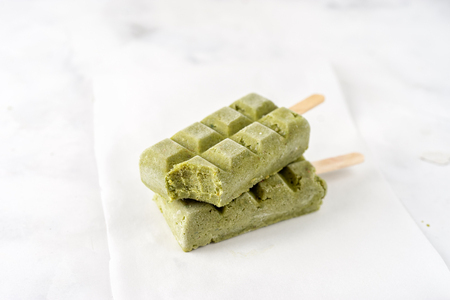 Two green vegan sorbet popsicles on white backgroundの写真素材