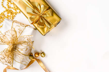 Topv view of golden Christmas gifts on white wooden background