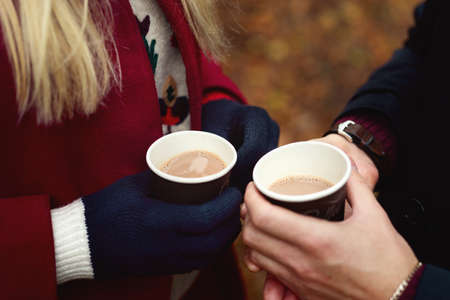 Close up of hands holding paper cups of coffee outdoorsの写真素材