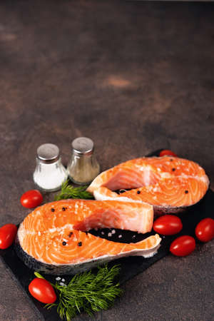 Top view of two raw fresh salmon rich in omega-3 oil on a dark background. Healthy and dietary food. Copy space. Fの写真素材