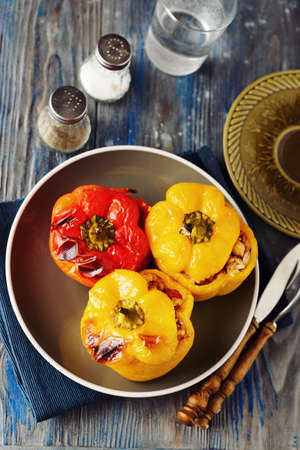 Colorful stuffed veggie peppers with rice and chickpea on blue rustic table