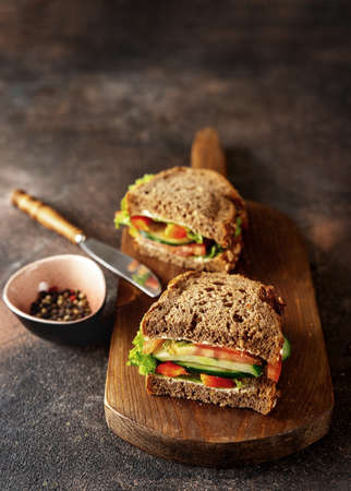 Prepared vegan sandwiches on a board and dark rustic backgroundの写真素材