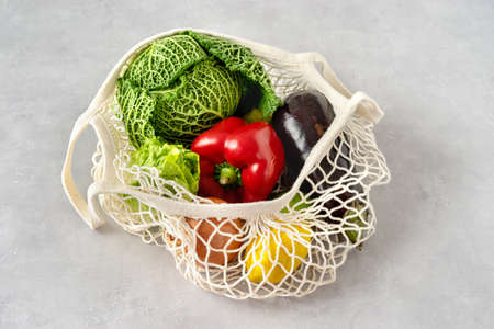 Healthy vegetables in reusable cotton net bag on light backgrund. Zero waste conceptの写真素材