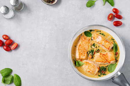 Delicious salmon steaks in cream sauce and frying pan. Copy spaceの写真素材
