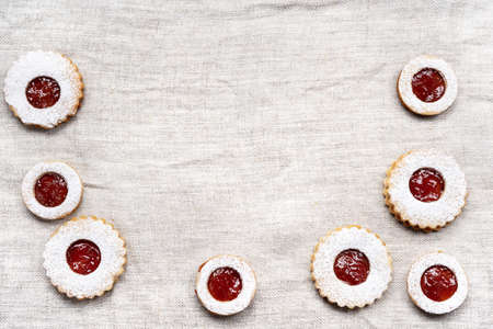 Homemade linzer cookies on light wrinkled cloth for Christmas with copy space. Top viewの写真素材