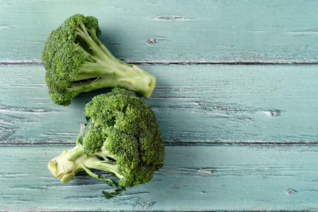 Fresh broccoli on blue wooden table with copy spaceの写真素材