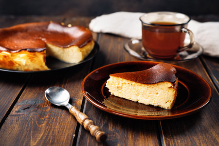 A piece of delicious basque burnt cheesecake with cup of teaの素材 [FY310161985599]