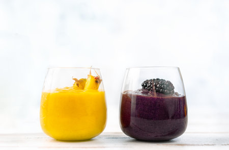 Colorful yellow and blue smoothie in two glassesの写真素材