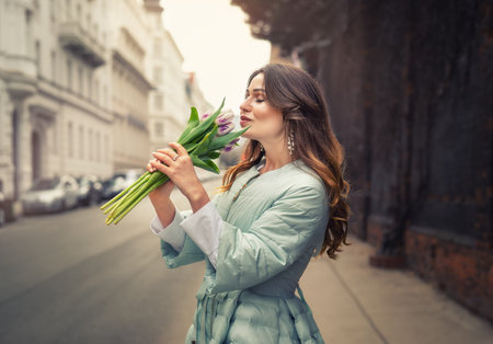Portrait of young elegant woman in spring blue coat with tulipsの写真素材