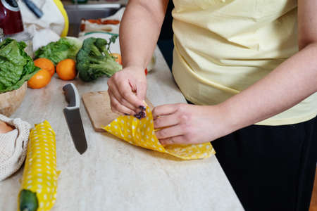 Unrecognisable woman wrapping cucmber in beeswax clothの写真素材