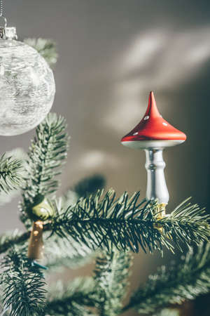 Glass mushroom deco on Christmas tree. Shadows on the wall. Trendy DIY and zero waste conceptの写真素材