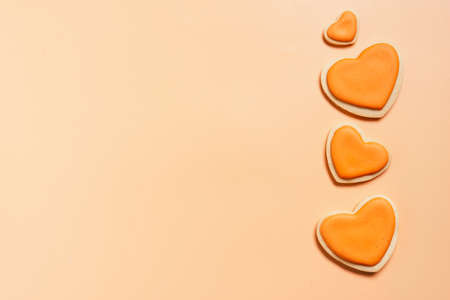 Valentines day sugar cookies of heart shape on calm coral background. Minimal composition with copy spaceの写真素材
