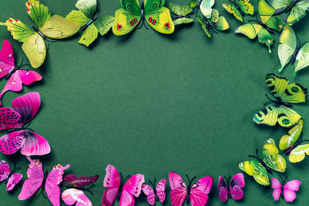 Abstract emerald color background with artificial green and purple butterflies. Mock up with copy...