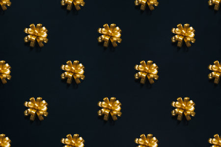 Golden bow pattern for present on black background. Black friday or Christmas holidays conceptの写真素材