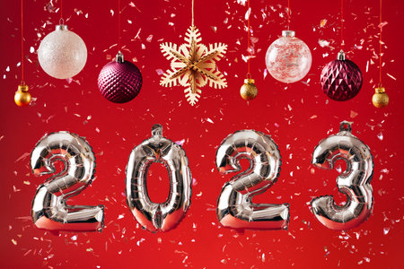 2023 New Year Celebration - silber balloon numbers and decorations on bright red glitter background
