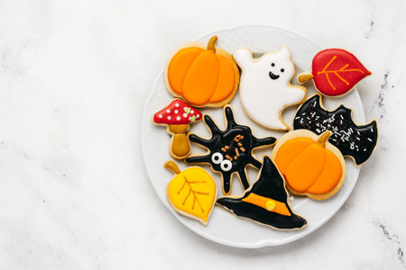 Halloween sugar cookies - pumpkin, ghosts, witch hat, spider in a plate on white background. Top viewの写真素材