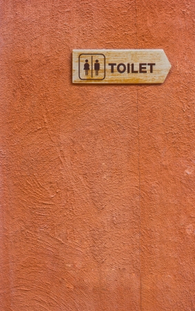 Wooden Toilet Sign on The Orange Wall の写真素材