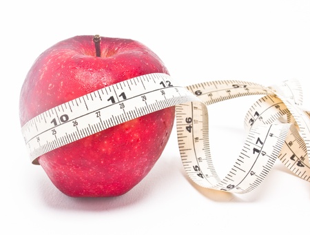 Red apple and measure tape isolated on white background の写真素材