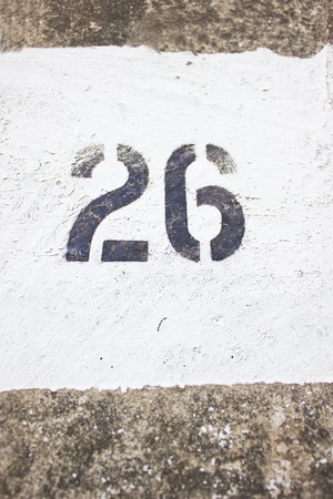 Number 26 on concrete wall with white painting.の写真素材