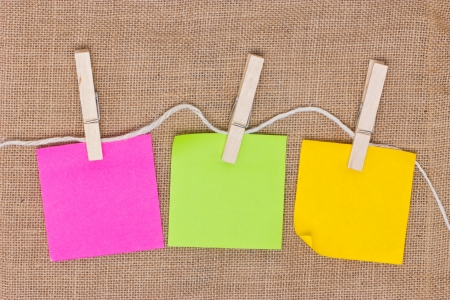 Colorful sticky notes with clothespins on burlap background の写真素材