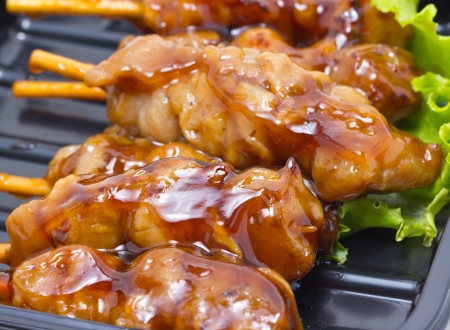 Chicken teriyaki with skewers inblack tray の写真素材