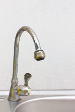Old and dirty kitchen faucet and sink の写真素材