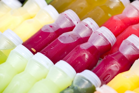 Assortment of cold tropical fruit juice in bottles の写真素材