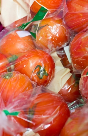 Close up of fresh tomatoes packed in transparent plastic bag in the market.の写真素材