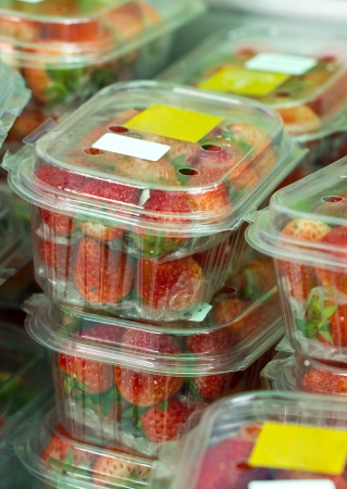 Fresh strawberries in closed plastic boxes in market.の写真素材