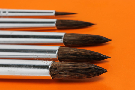 Close Up Of Artistic Brushes On Orange Backgroundの写真素材