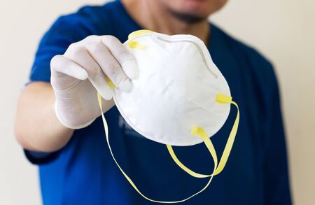 Asian Men Wear Medical Gloves And Hold Medical Masks N95. In Order to Campaign to Wear to Prevent the Corona Virus that is Spreading Around the World.の写真素材