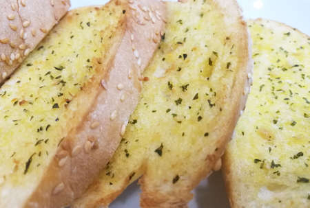 Close Up Garlic Bread on Plate, Garlic bread stems from bruschetta, which appeared in Italy around the 15th century, and can be traced back to Ancient Rome.の写真素材
