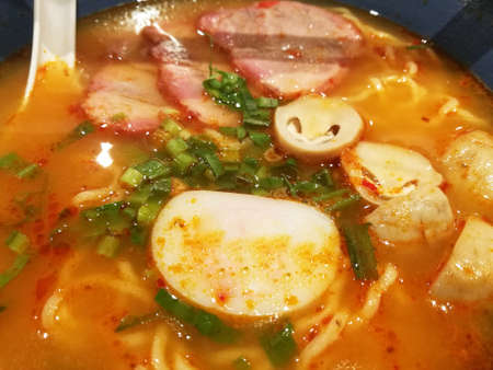 Close Up Tom Yum Ramen Pork and Chopsticks in Bowl.の写真素材